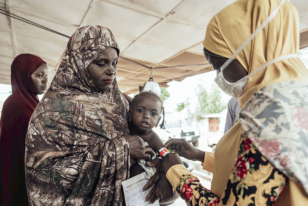 Terveydenhuollon työntekijä mittaa Sadiya Tukurin 2,5-vuotiaan Sharhabila-tyttären olkavarren ympärysmitan Kebbissä Nigeriassa.