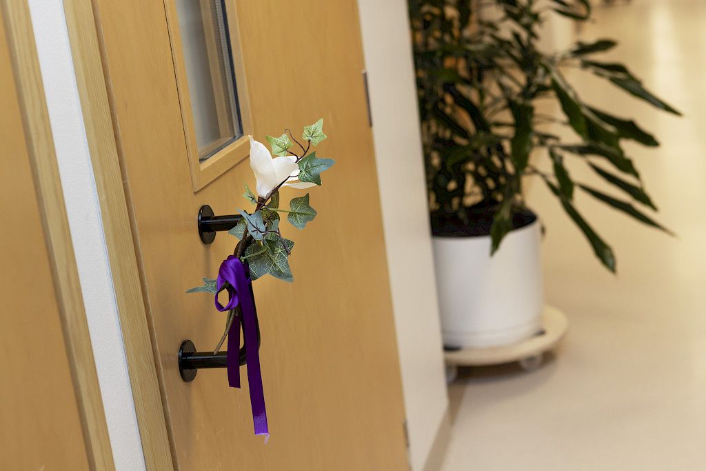 Saattohoitokodin oveen on ripustettu kukka. Se on merkkinä siitä, että huoneessa ollut potilas on juuri kuollut.