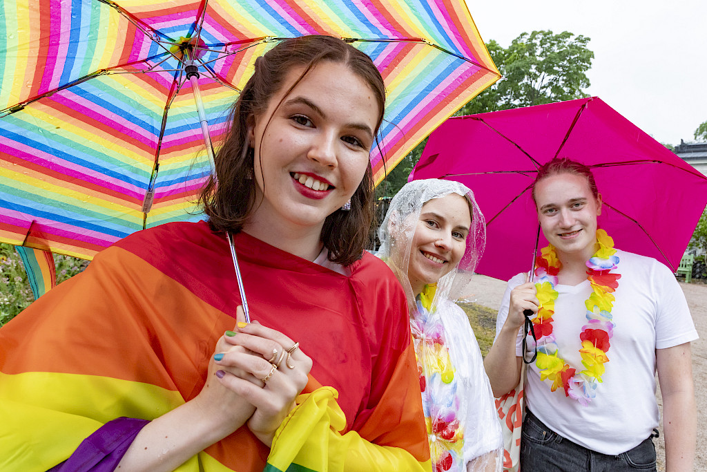 Turun lääketieteellisessä opiskelevat Tania Harjunpää (vas.), Iida-Maria Paavola ja Veikko Pulkki nauttivat Helsingin Pride-tapahtuman tunnelmasta rankkasateesta huolimatta.